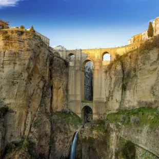 Village Ronda sitting on rocky clifftops and Puente Nuevo, a bridge in Ronda in Andalusia, Spain.